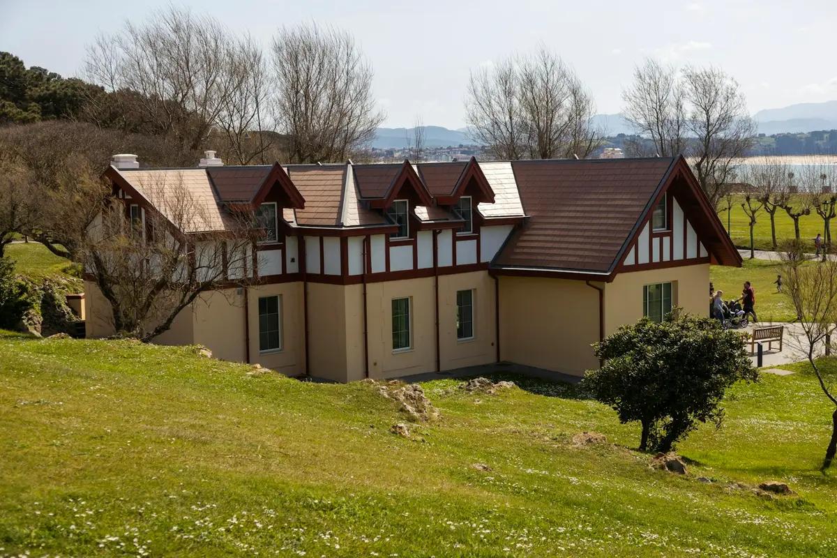 Una casa con jardín y el mar al fondo